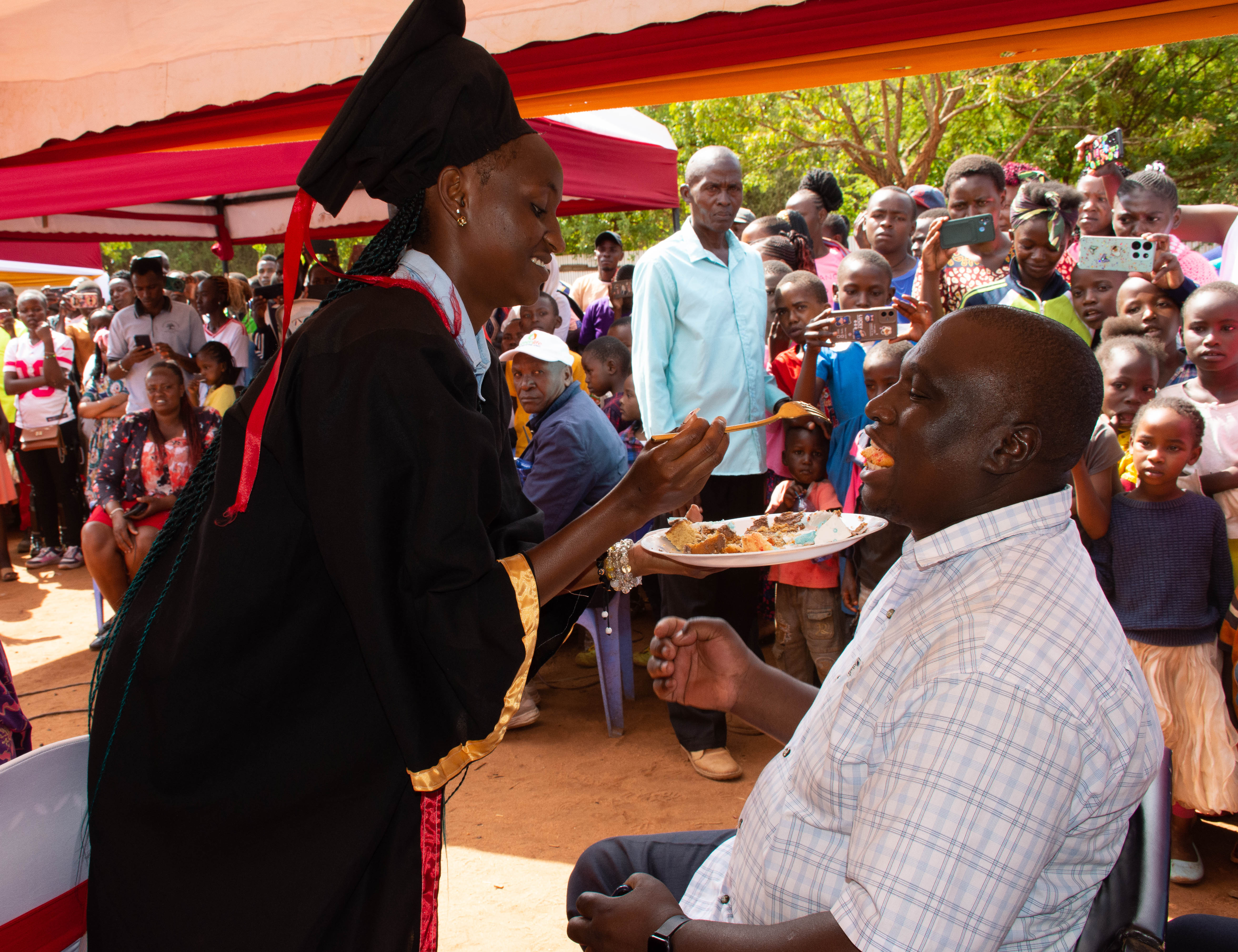 GRECA Chairperson Mr.Wakala being given a cake during the graduation ceremony